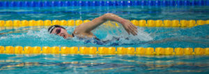 A woman racing freestyle in the pool.