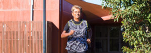 Aunty Pam running outside a building and toward the camera.