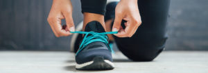 A close up of someone tying the shoe laces on their running shoes.