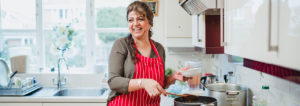 Woman happily cooking in the kitchen.