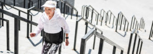 Elderly woman happily walking up stairs.