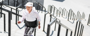 Elderly woman happily walking up stairs.