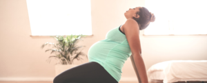 Pregnant woman stretching at home