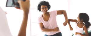 Mother and daughter dancing in living room