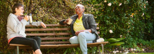 Two people laughing on a park bench